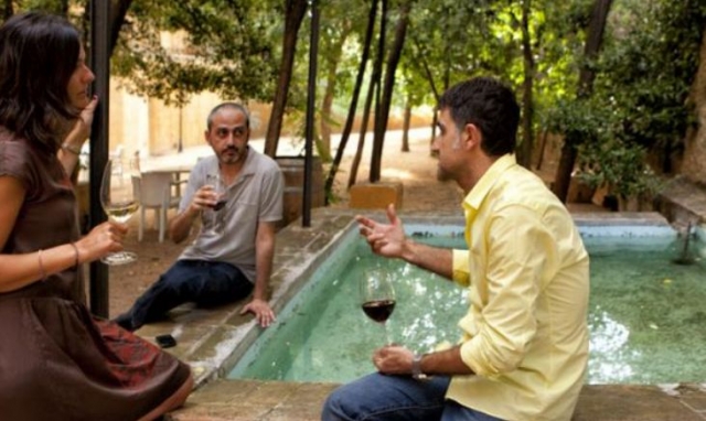 tres personas bebiendo una copa de vino en una fuente